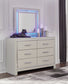 Zyniden King Upholstered Panel Bed with Mirrored Dresser and Nightstand